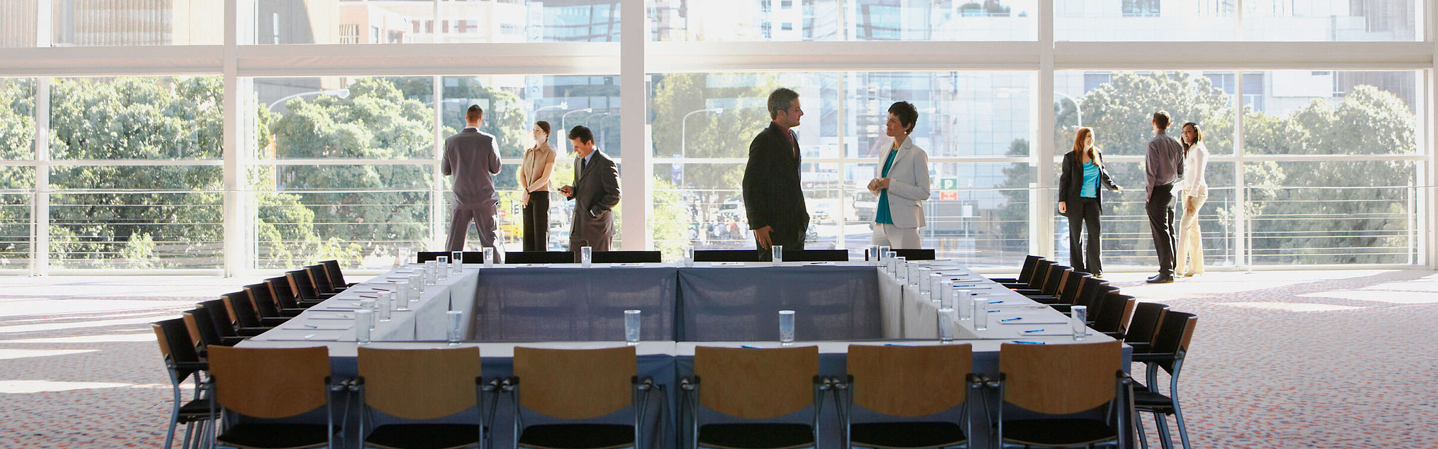 Gruppe von Personen im Meetingraum mit großem Fenster