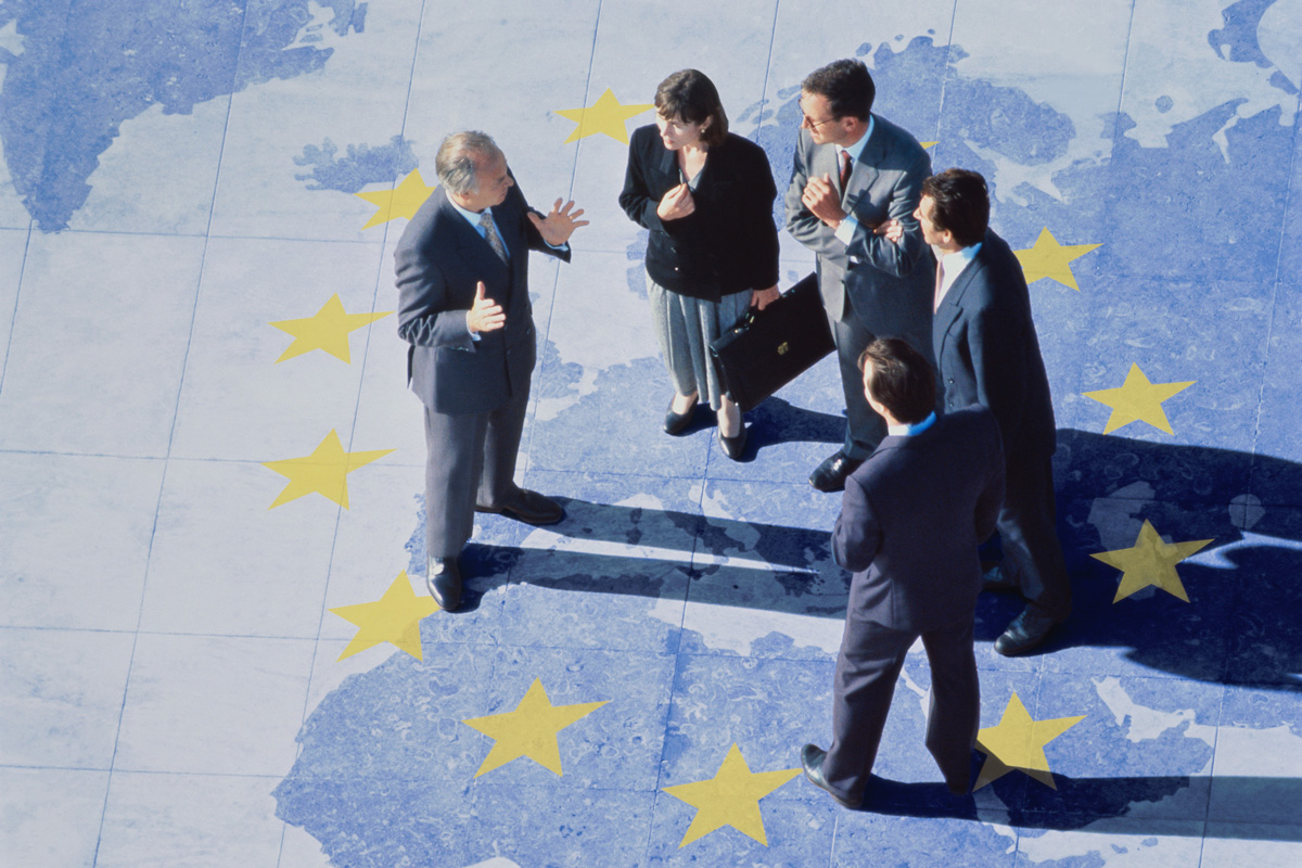 Symbolbild: 28. Regime europäisches Gesellschaftsrecht: Gruppe von Unternehmer stehen auf EU-Karte mit Sternen
